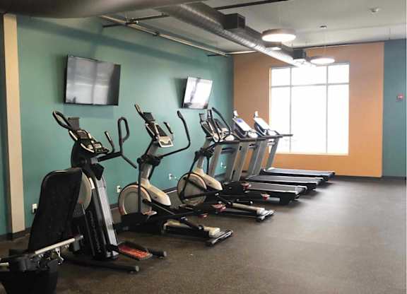 a gym with a row of exercise bikes at The Pomenade at Founders Square Apartments in Portage, IN