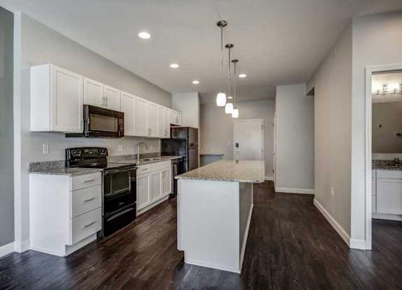 an empty kitchen with white cabinets and a counter top