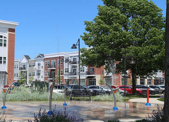 a fountain in a park in front of some buildings