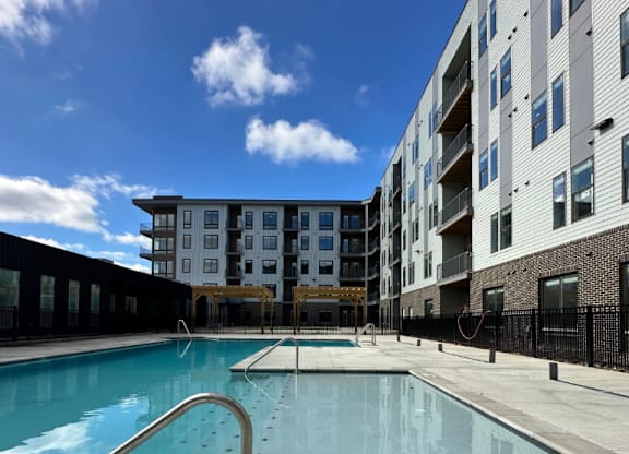 A sparkling swimming pool with wide, shallow entry steps in front of the Fitzroy Apartments in Birmingham, Alabama.