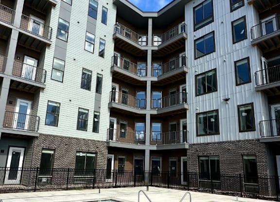A sparkling swimming pool with wide, shallow entry steps in front of the Fitzroy Apartments in Birmingham, Alabama.
