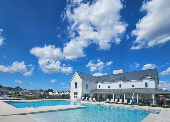 a large swimming pool with a white building in the background at The Cottages at Foley Farms apartments in Foley, AL