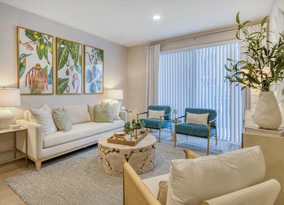 A living room with a white couch, a coffee table, and a painting on the wall.