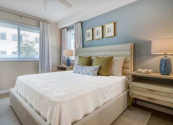 A bedroom with a large bed and a ceiling fan.