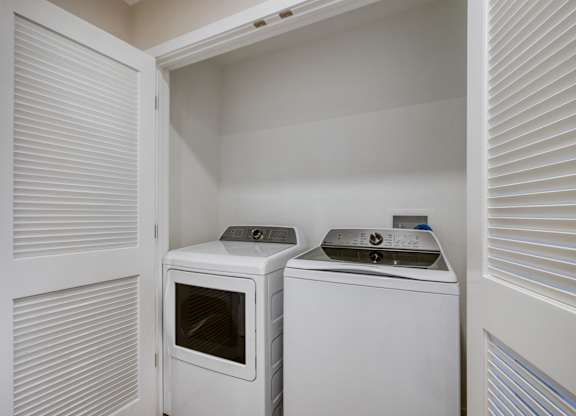 A small white laundry room with a washer and dryer.