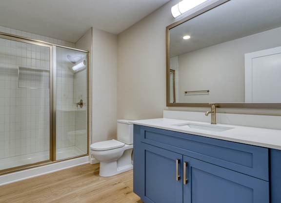 A bathroom with a toilet, sink, and shower.