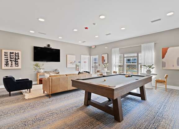 A room with a pool table and a tv.