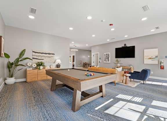 A room with a pool table and a television.