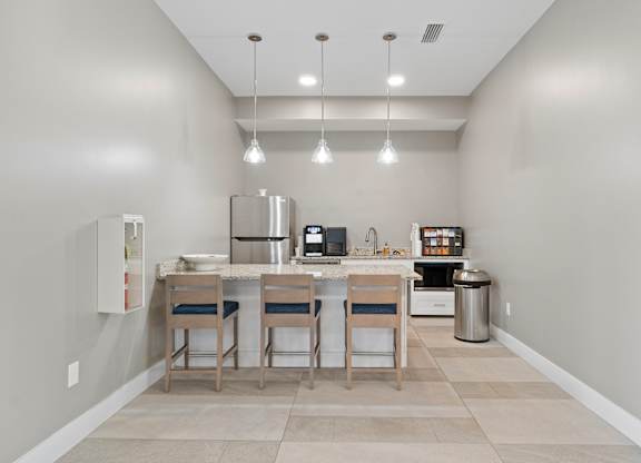 A kitchen with a table and chairs.
