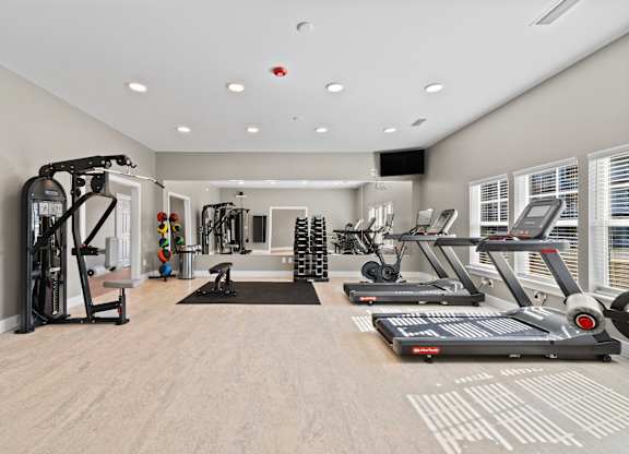 A spacious gym with treadmills, elliptical machines, and other exercise equipment.