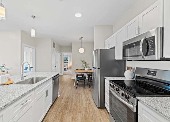A modern kitchen with stainless steel appliances and white cabinets.