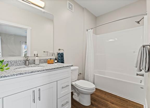 A white bathroom with a toilet, sink, and shower.