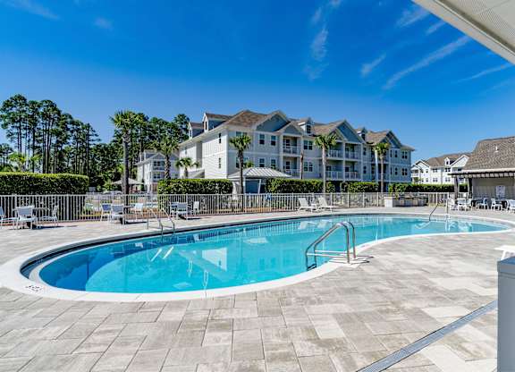 A large swimming pool in front of a resort.