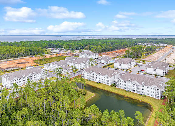 A bird's eye view of a resort with a lake and buildings.