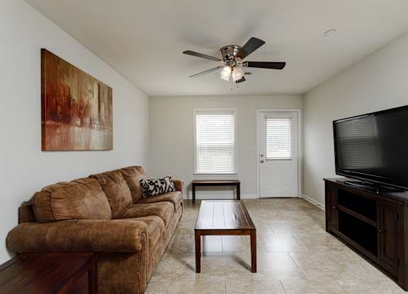 A living room with a brown couch and a television.