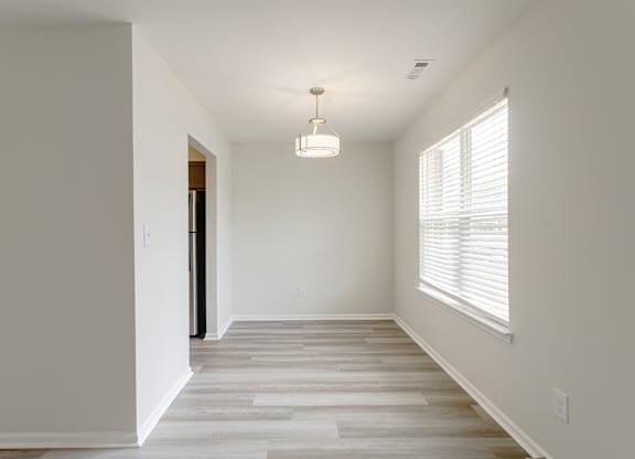 A room with a light on the ceiling and a door on the left.