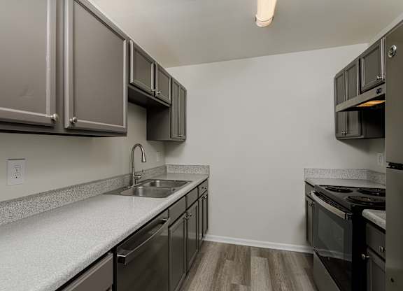 A kitchen with stainless steel appliances and wooden floors.