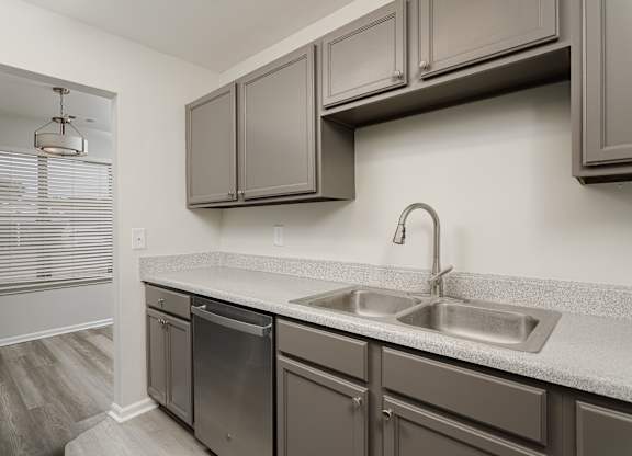 A kitchen with a stainless steel dishwasher and a sink.