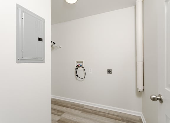 A white door is open to a hallway with a white wall and a white door.