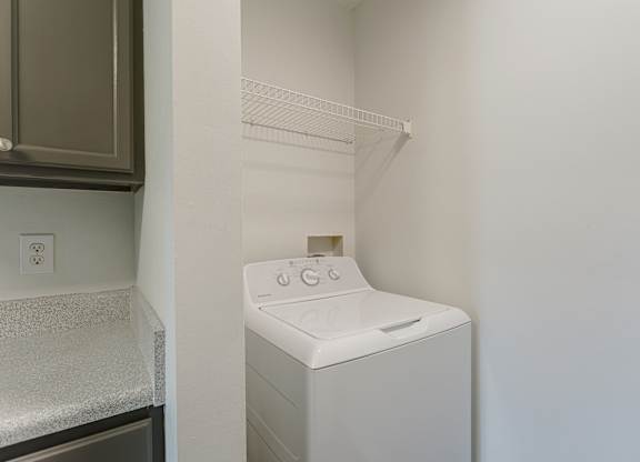 A white dryer is sitting in a small laundry room.
