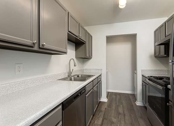 A kitchen with a sink, stove, and refrigerator.