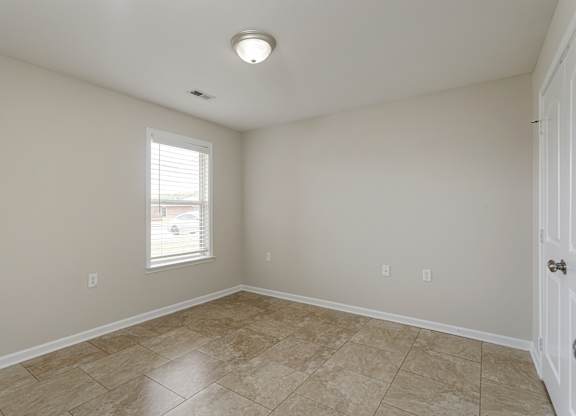 A room with a tiled floor and a window letting in light.