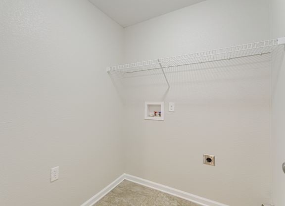 A white wall with a shelf and a picture frame on it.