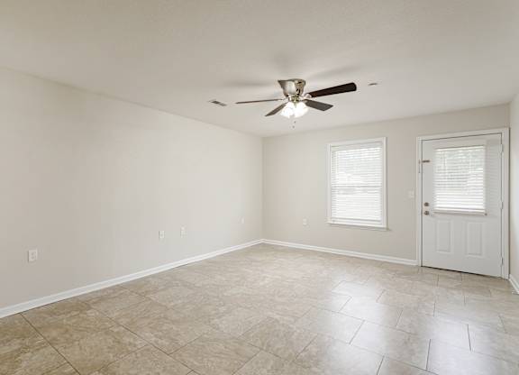 A room with a ceiling fan and tile flooring.