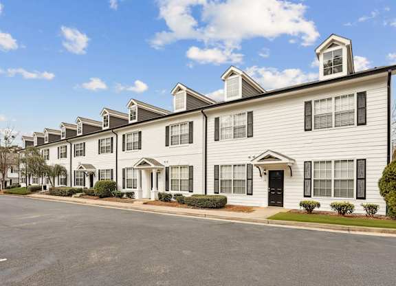 A row of townhouses with a clear blue sky above them.
