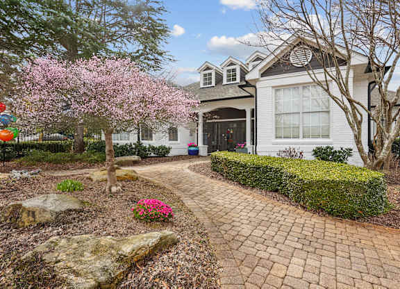 A house with a brick pathway leading to the front door.