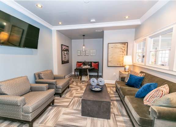 A living room with a grey couch, a brown armchair, and a coffee table.