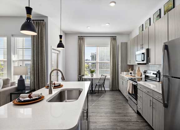 A modern kitchen with a large island and stainless steel appliances.