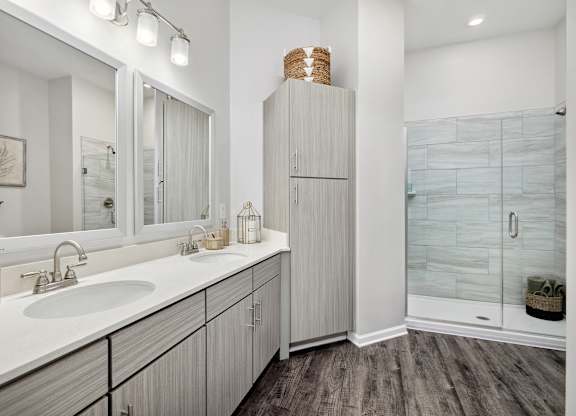 A bathroom with a white sink and a wooden cabinet.