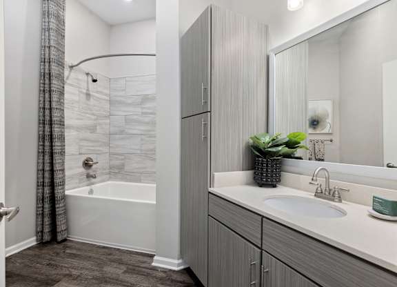 A bathroom with a white tub and sink.