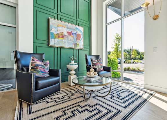 a living room with two black leather chairs and a green door