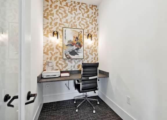 a desk in a room with a chair and a painting on the wall