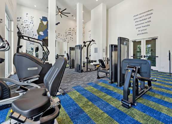 a gym with treadmills and other exercise equipment in the lobby of a building