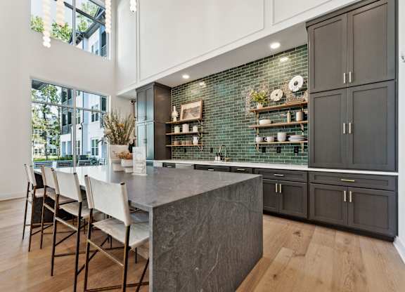 a kitchen with black cabinets and a marble counter top
