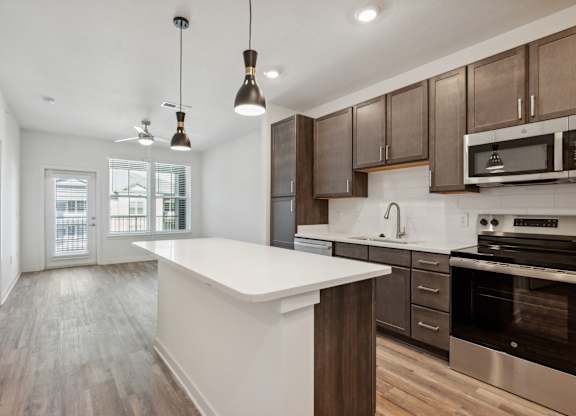 an open kitchen with a large white counter top in a new home