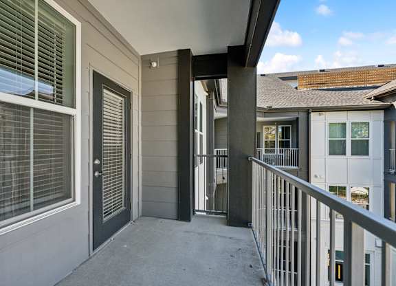 a balcony with a railing and a building with windows and a door