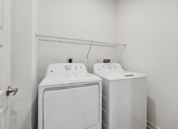 a white washer and dryer in a white laundry room