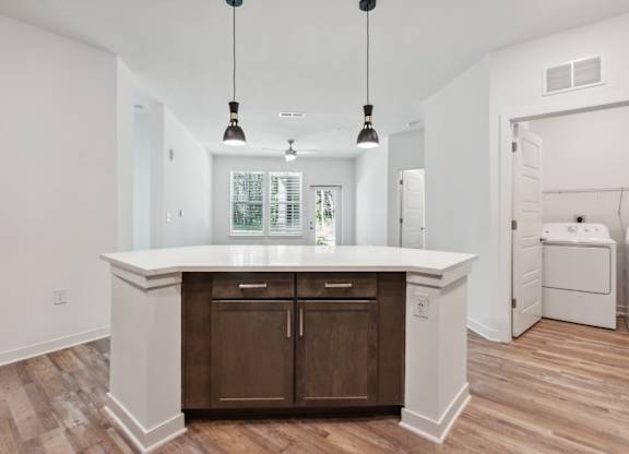 a white kitchen with wooden floors and a white counter top