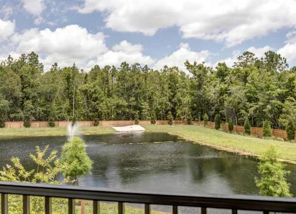 A fountain in the middle of a lake surrounded by trees.