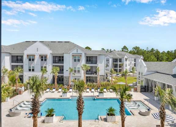 A large white building with a pool in front.