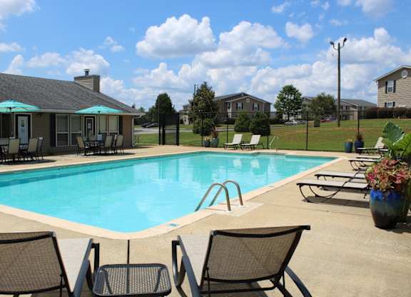 Pool with sundeck, tables, and chairs at The Avery at Auburn Apartments in Auburn, AL
