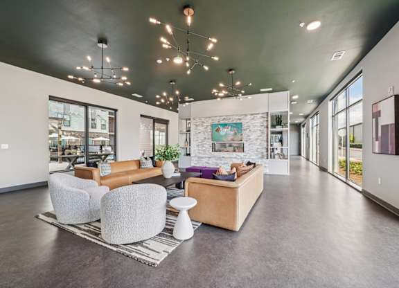 A spacious living room with a grey floor and a stone wall.