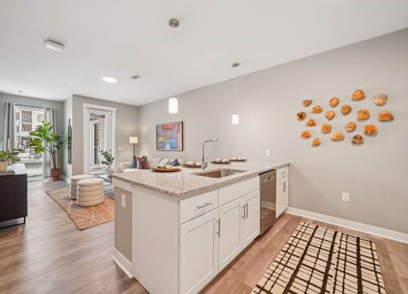 A kitchen with a white counter top and cabinets.