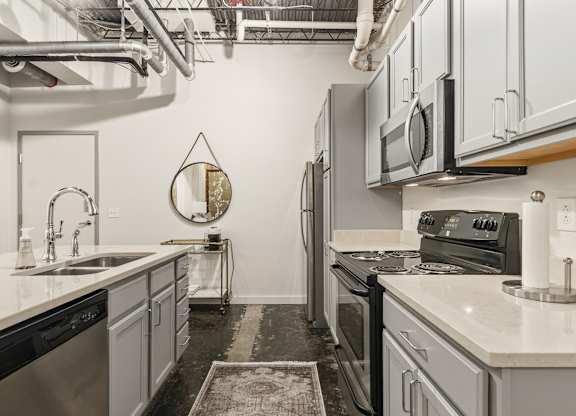 A kitchen with a black and white theme at The Tower Apartments, Alabama, 35401