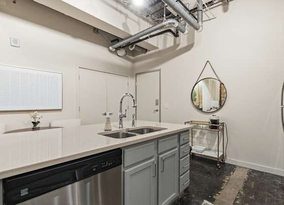 A kitchen with a stainless steel dishwasher and a refrigerator at The Tower Apartments, Alabama, 35401