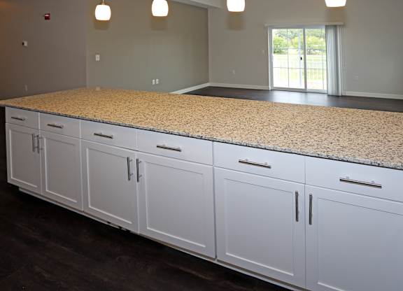 oversized breakfast bar with cabinets, pendant lighting, and granite countertop EV charging stations at Promenade at Founders Square Apartments in Indianapolis, IN